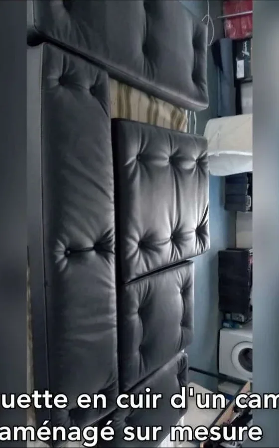 Banquette capitonnée en cuir noir d'un camion aménagé sur mesure, réalisée par Ets Reyberolle sellier garnisseur